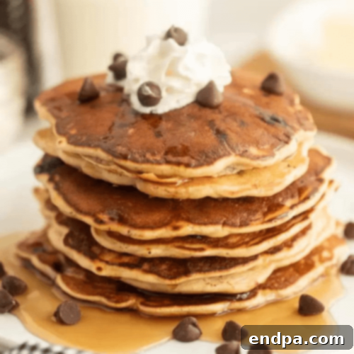 A tall stack of Chocolate Chip Pancakes, overflowing with melted chocolate chips.