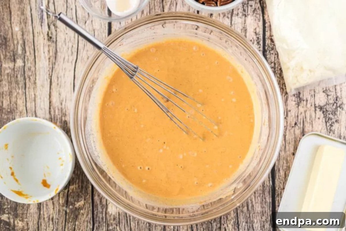 Mixing Pumpkin Cake Batter A mixing bowl filled with the pumpkin, evaporated milk, and sugar mixture, ready for the next ingredients.