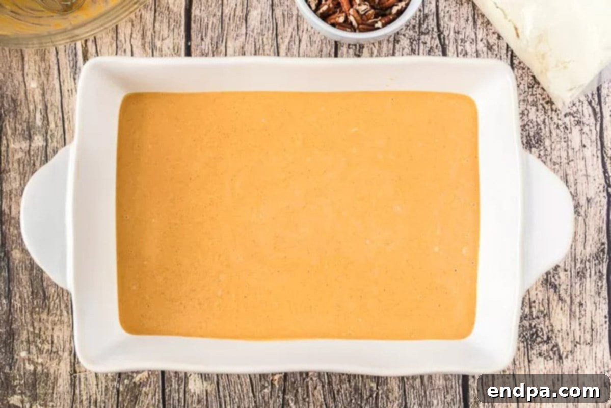 Pumpkin Batter in Baking Pan Pumpkin cake batter freshly poured into a greased 9x13 inch baking pan.