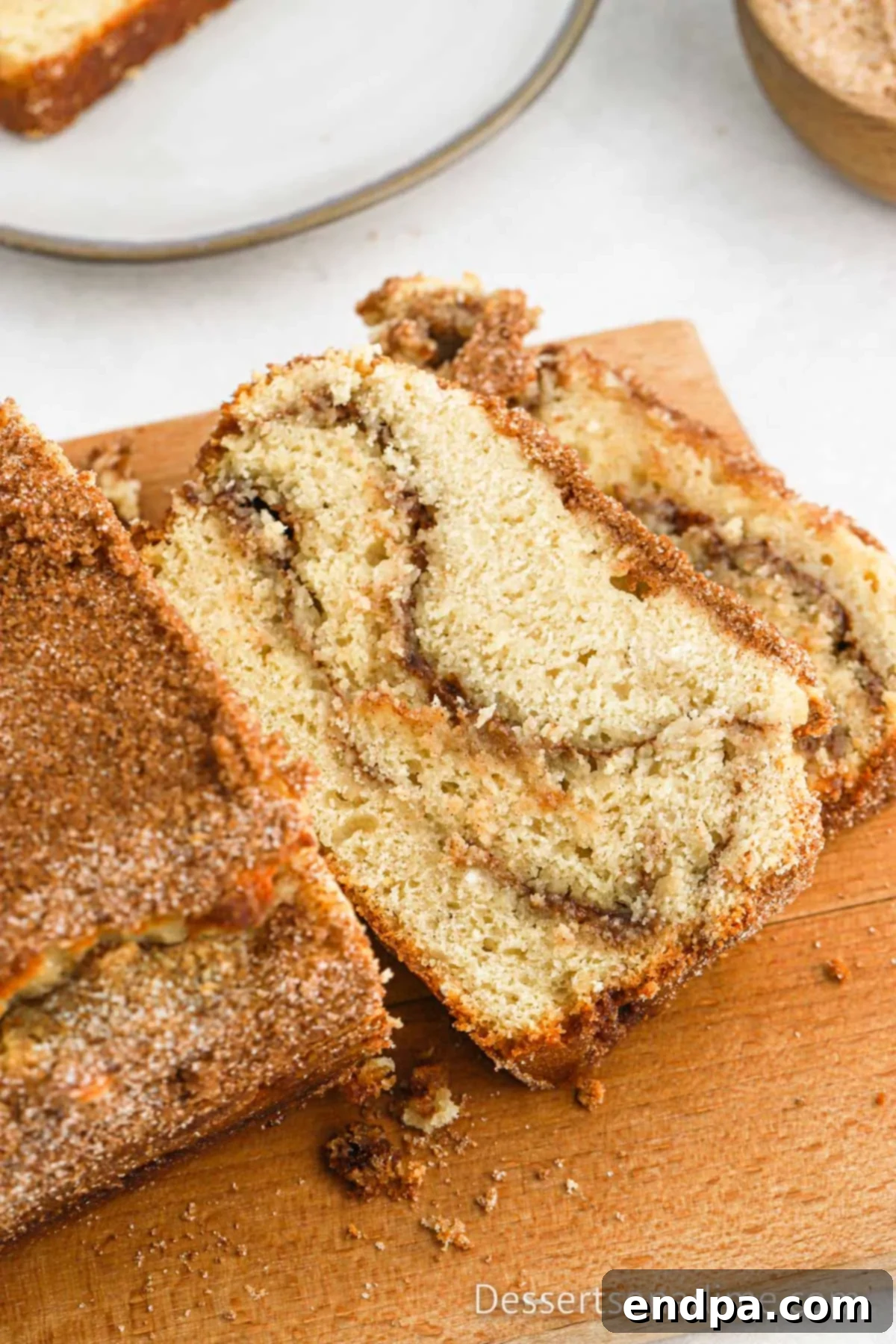 Close-up of freshly sliced snickerdoodle bread, revealing the intricate cinnamon sugar swirls within.