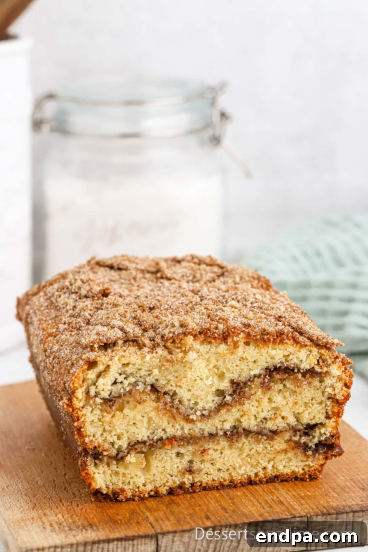 A full loaf of freshly baked snickerdoodle bread, showcasing its golden-brown crust and inviting texture.