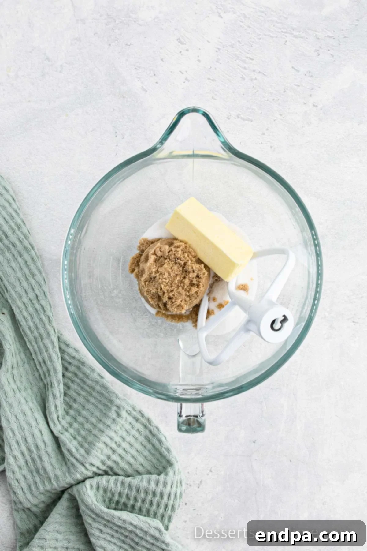Mixing bowl with softened butter, granulated sugar, and brown sugar being creamed together.