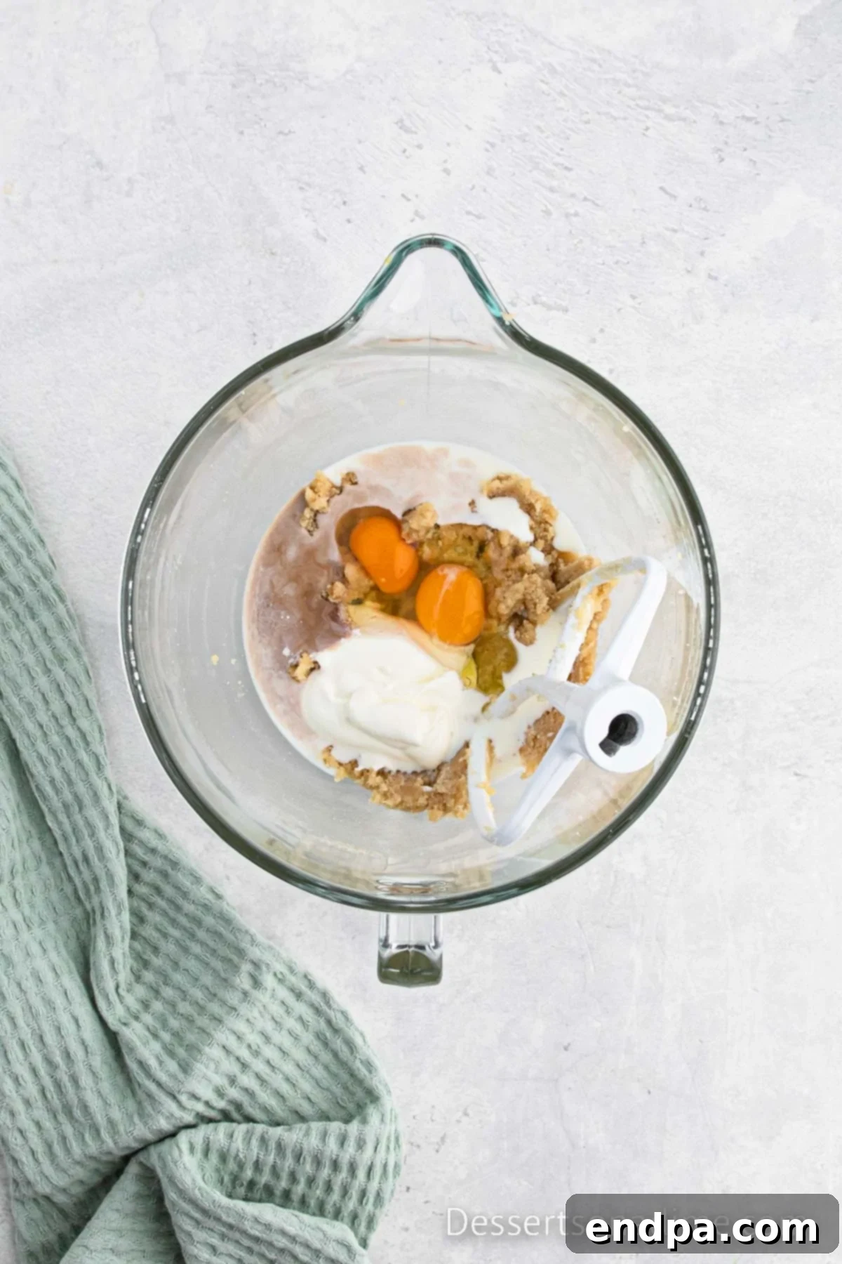 Mixing bowl with eggs, milk, sour cream, and vanilla extract added to the creamed butter and sugar mixture.