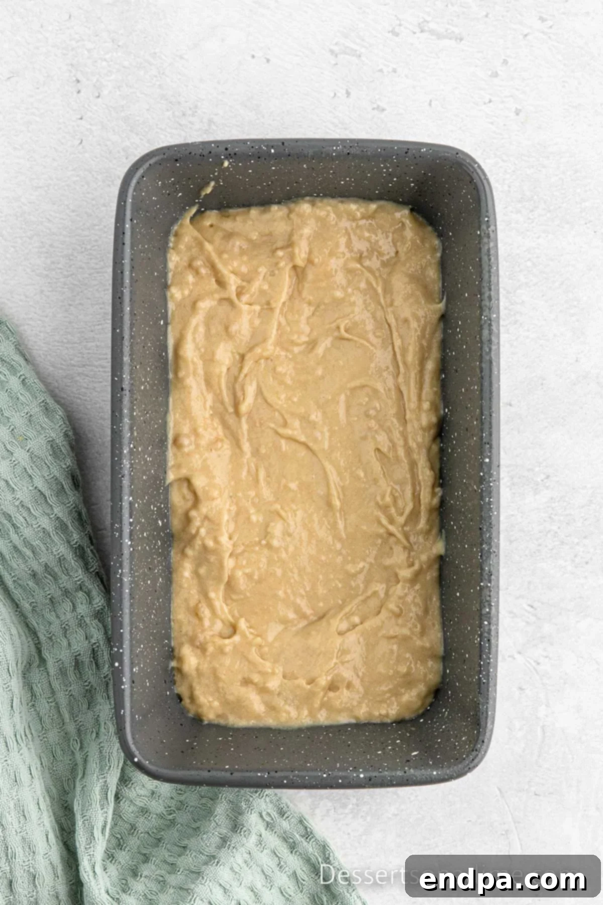 Loaf pan with the first layer of bread batter spooned in.
