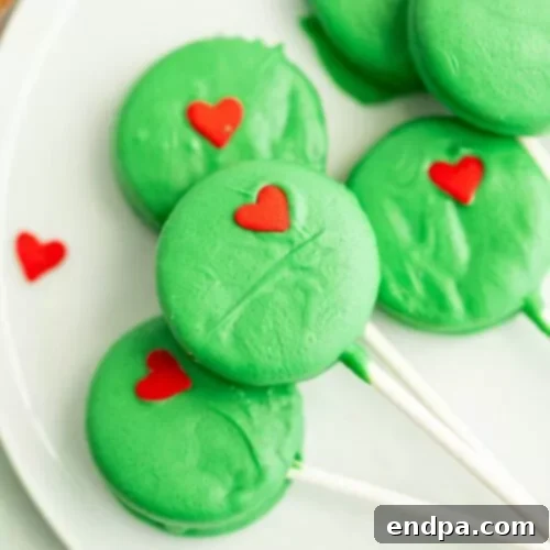 Grinch Oreo Pops with green candy melt and a heart