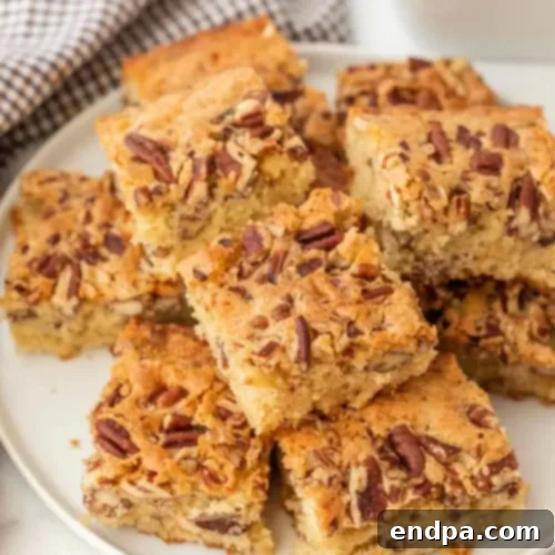 Close-up of a freshly baked loaf of Pecan Bread, sliced to show the pecan pieces, on a wooden cutting board.