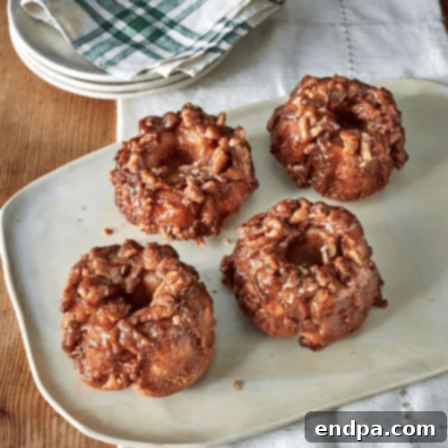 Mini Pecan Monkey Bread Loaves drizzled with caramel sauce on a white plate, perfect for brunch.