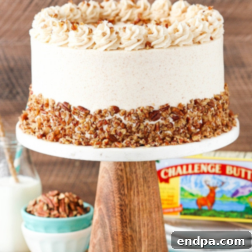 A slice of Browned Butter Pecan Layer Cake on a white plate, showing the layers.