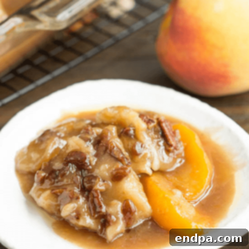 Peach-Pecan Cobbler in a baking dish, with a scoop of ice cream.