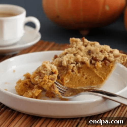 Pumpkin-Pecan Streusel Pie slice on a plate.