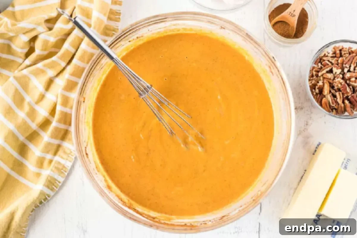 Bowl of pumpkin mixture combined in a mixing bowl.
