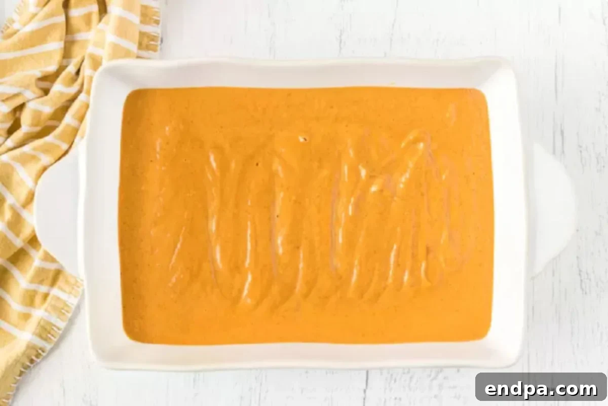 Pumpkin batter spread evenly into a 9x13 inch baking dish.