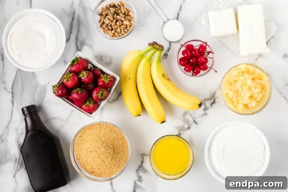 No bake banana split cake recipe is easy and always a hit. Layers of strawberries, crushed pineapple and more topped with chocolate make this one of the best no bake desserts. Everyone will enjoy banana split cake no bake recipe. #dessertonadime #bananasplitcake Close-up photo of all the ingredients laid out: graham cracker crumbs, butter, cream cheese, sugar, cool whip, sliced banana, pineapple, walnuts, chocolate syrup, and maraschino cherries.