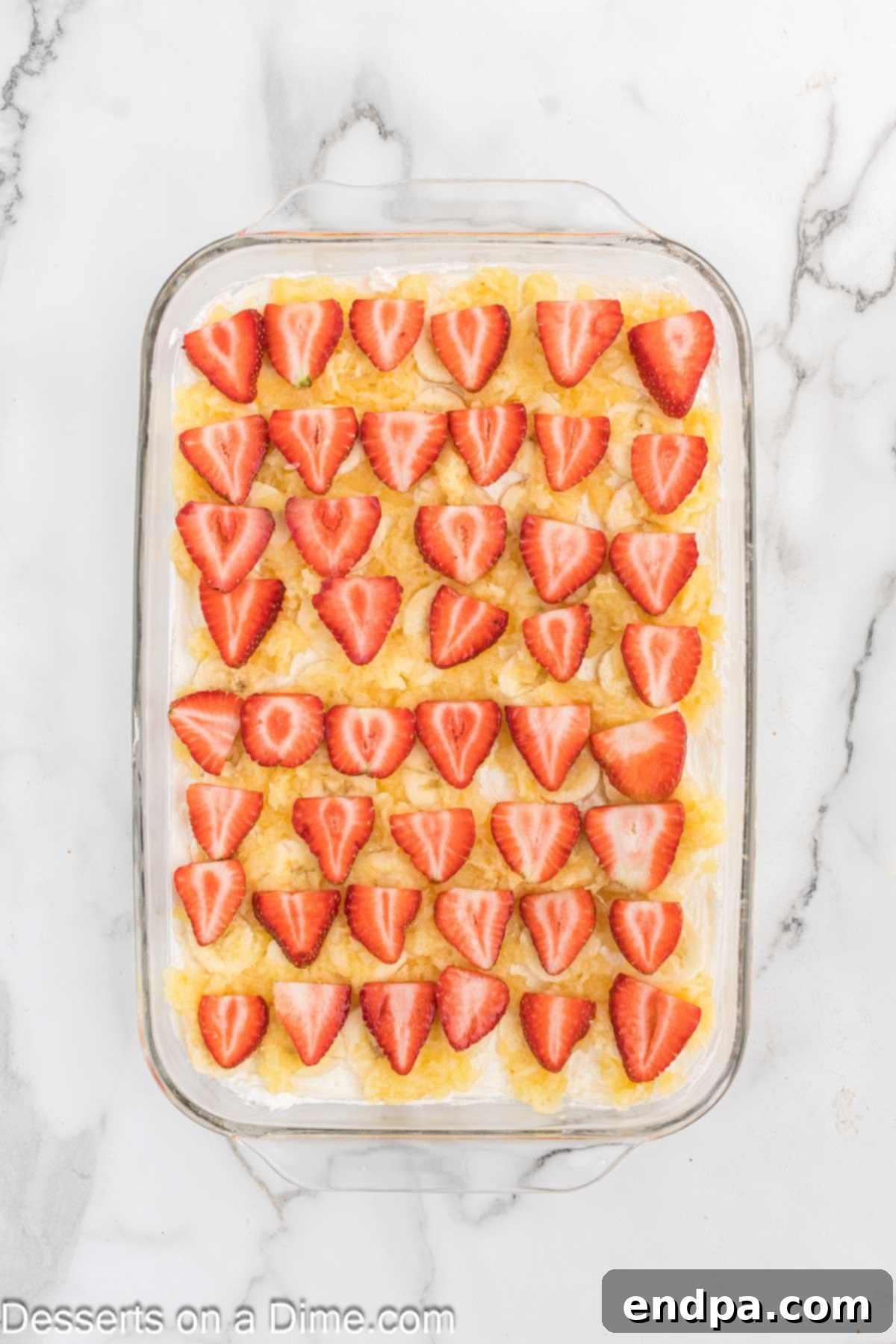 Banana Split Dream Cake 6 Bright red strawberry slices arranged artfully over the crushed pineapple layer.