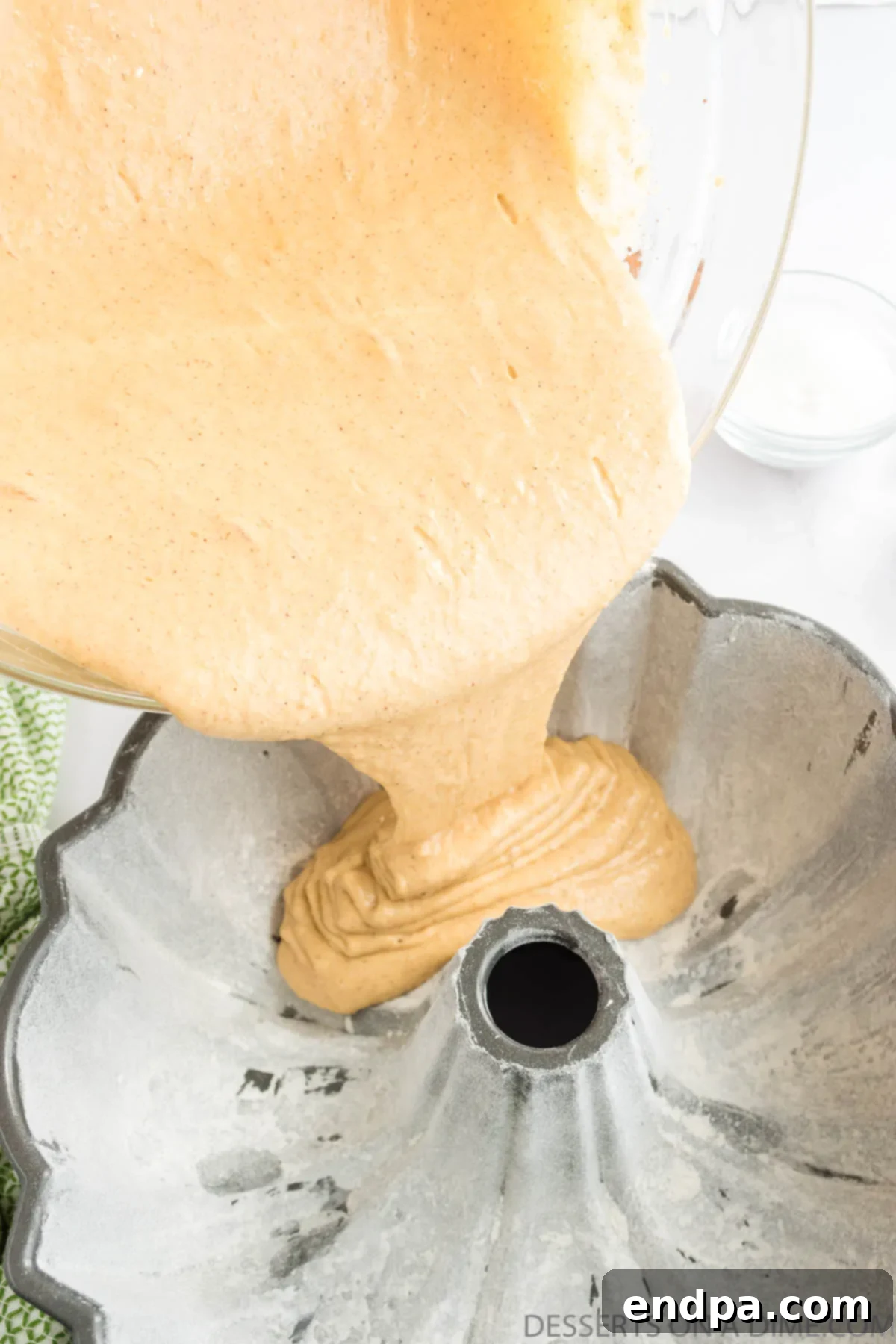 Autumn Apple Cider Bundt 6 Batter being poured into bundt pan.