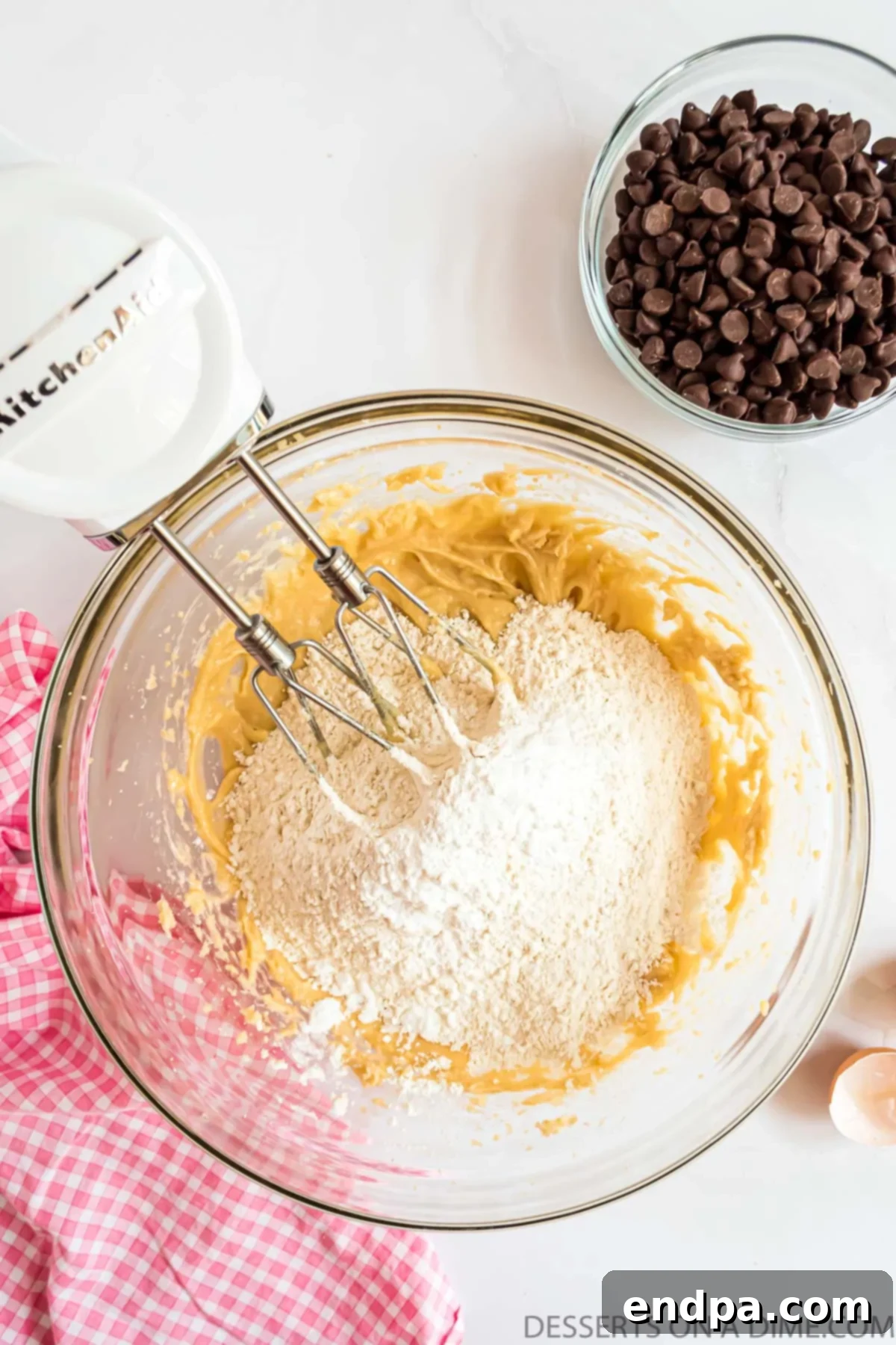 Dry ingredients (flour, cornstarch, baking soda, salt) being gradually added to the wet mixture.