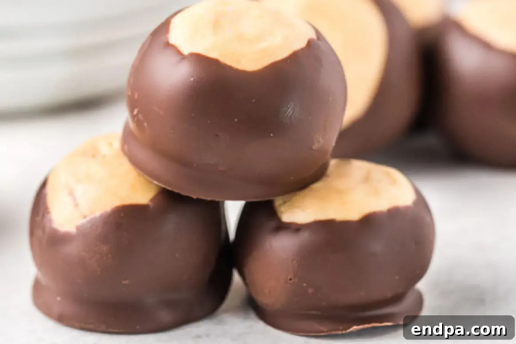 Buckeye Peanut Butter Delights 2 A collection of perfectly formed Buckeye Balls, showcasing their creamy peanut butter centers peeking through a smooth chocolate coating, arranged invitingly on a platter.