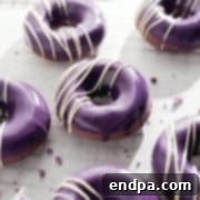 Vibrant Ube Donuts with a shiny purple ganache glaze.