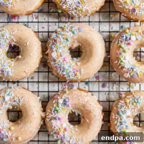 Baked Vanilla Bean Doughnuts with a deep vanilla glaze and festive sprinkles.