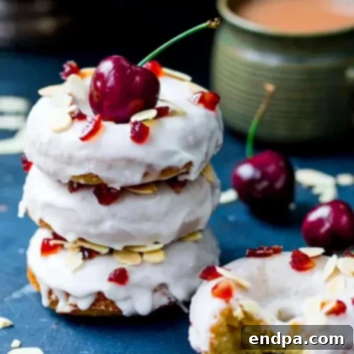 Baked Cherry Bakewell Doughnuts topped with glace cherries and flaked almonds.