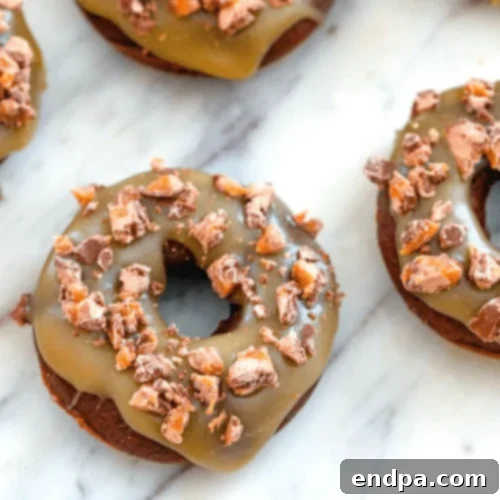 Milky Way Doughnuts topped with caramel and candy pieces.