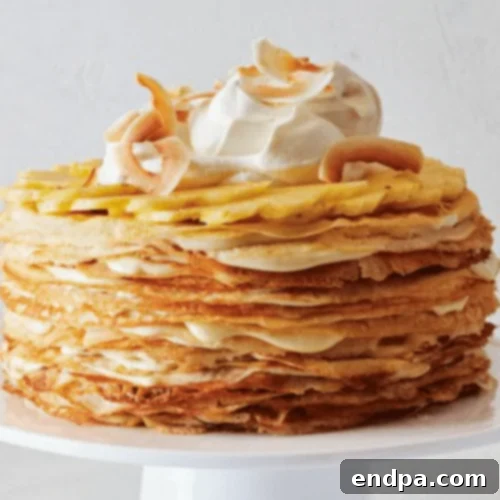 A beautifully layered Tropical Fruit Crepe Cake, adorned with fresh tropical fruits and coconut flakes.