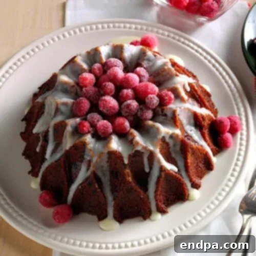 A festive Cranberry Orange Cake, generously drizzled with a bright lemon glaze and garnished with cranberries.