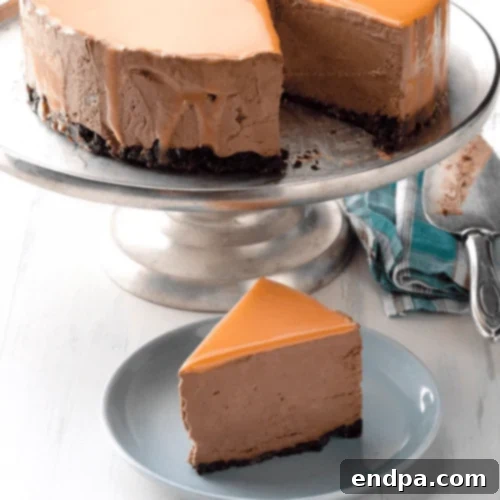 A perfectly glazed Orange Chocolate Mousse Mirror Cake, with a reflective, shiny surface.