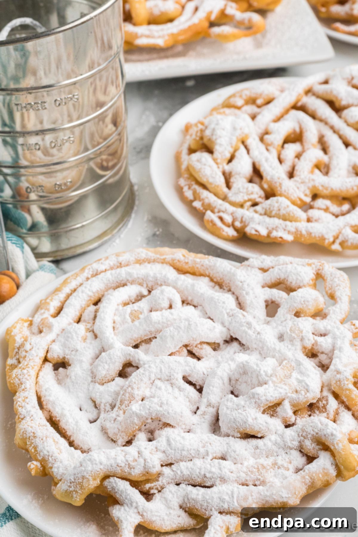A beautifully fried funnel cake dusted with powdered sugar, presented on a rustic plate, inviting to be eaten.