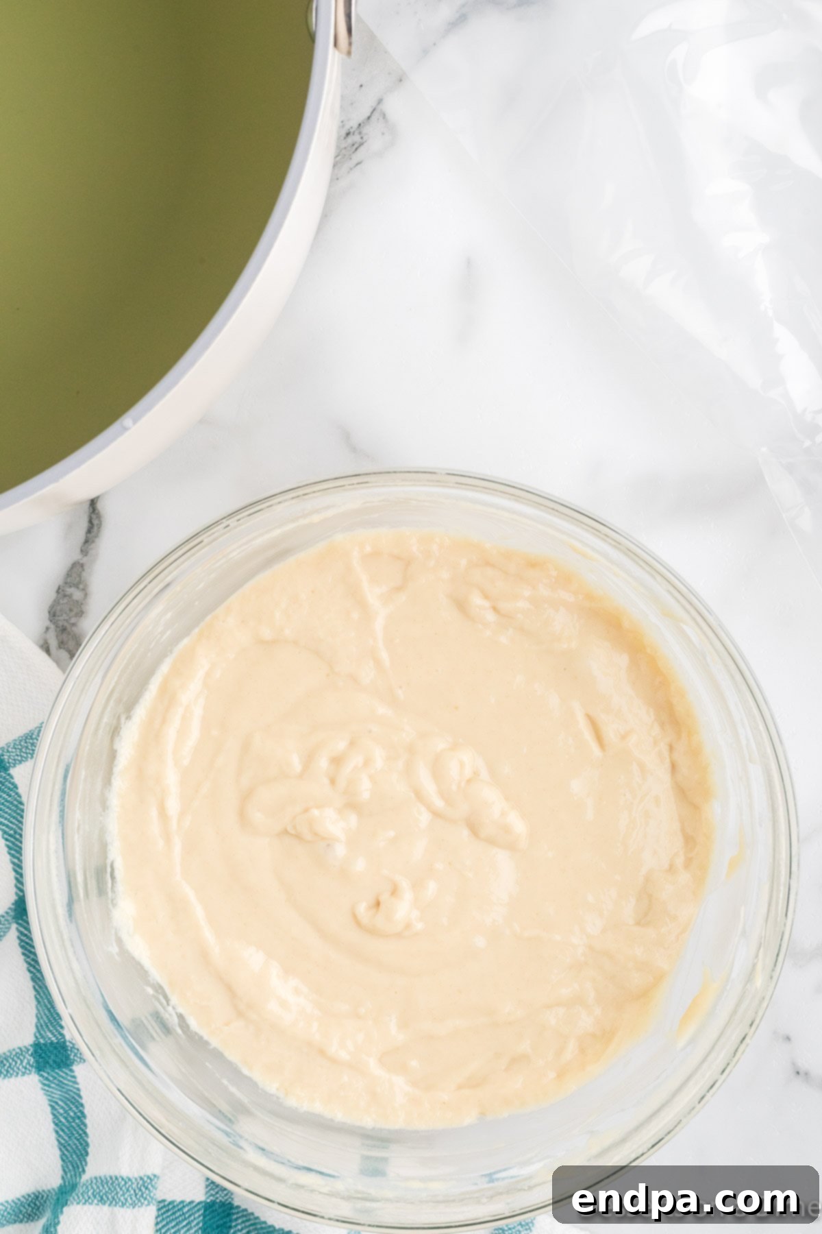 The smoothly combined funnel cake batter in a mixing bowl, ready for frying.