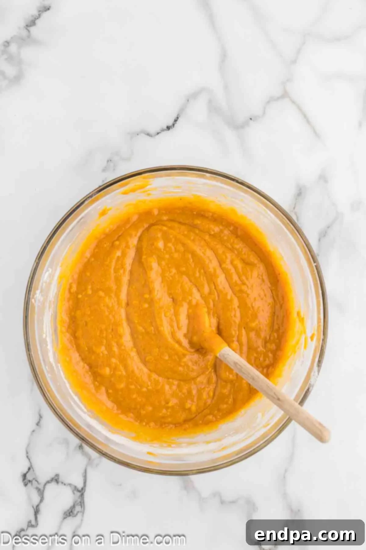 The pre-mixed dry ingredients are being carefully and gently poured into the bowl containing the wet ingredients. A wooden spoon is then used to stir the batter until the components are just barely combined, emphasizing the importance of not overmixing.
