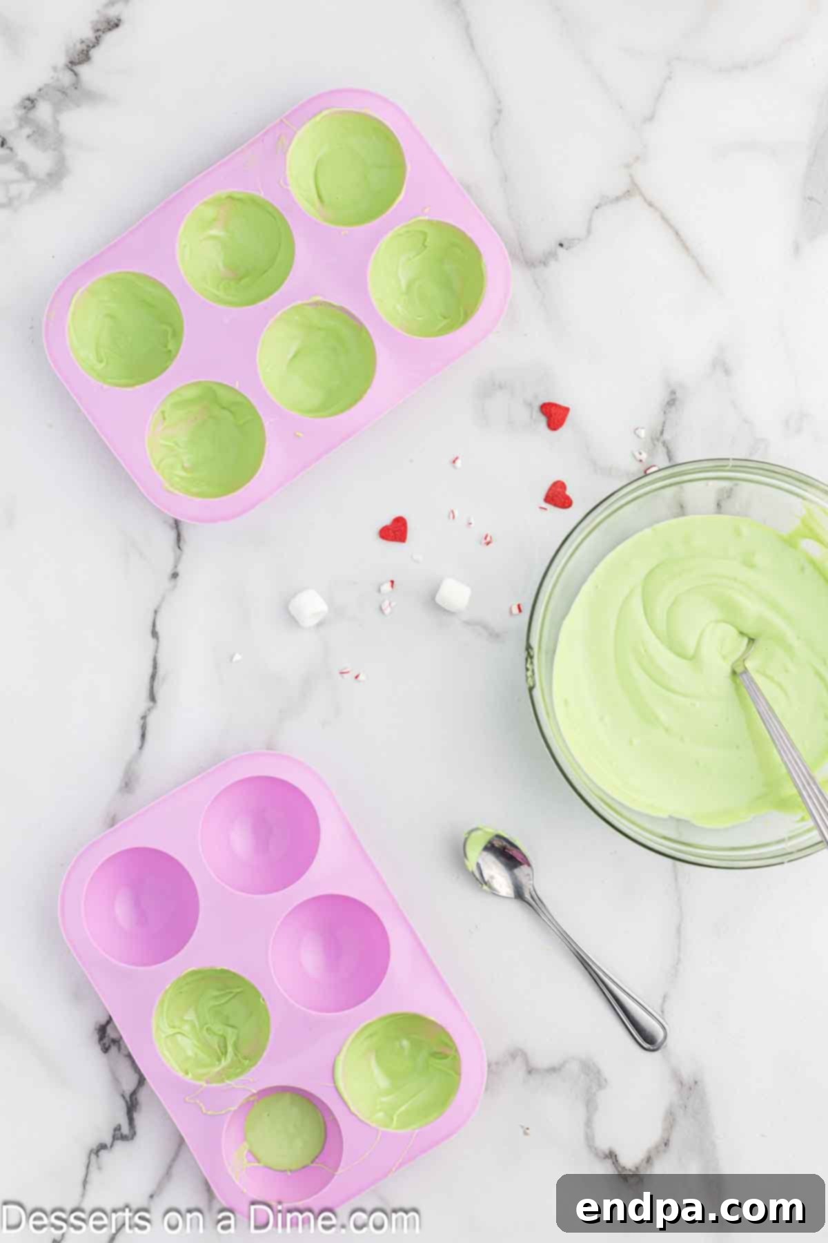 Grinchmas Hot Cocoa Bombs 5 Multiple layers of green candy melts being applied to the hot cocoa bomb molds.