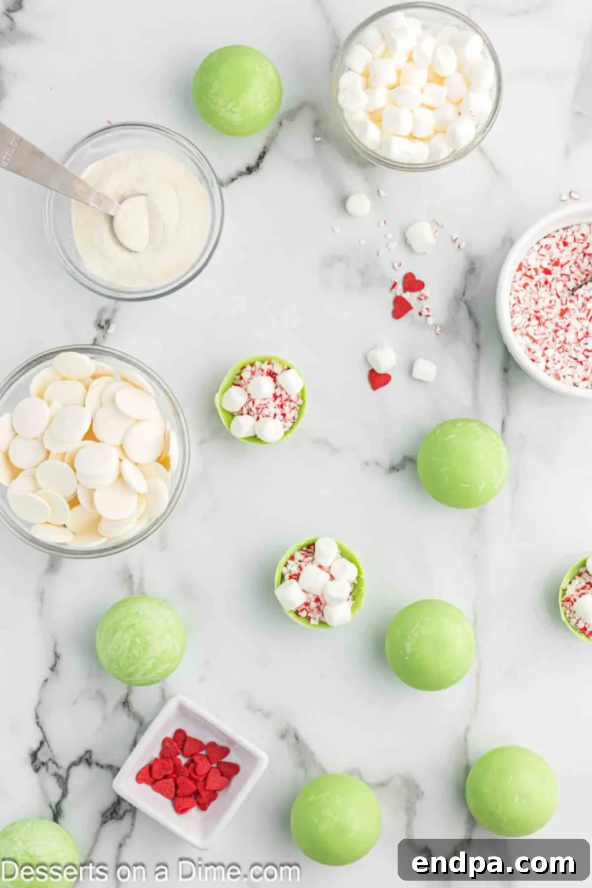 Grinchmas Hot Cocoa Bombs 7 Hot cocoa bomb halves being filled with cocoa mix, marshmallows, and candy canes.