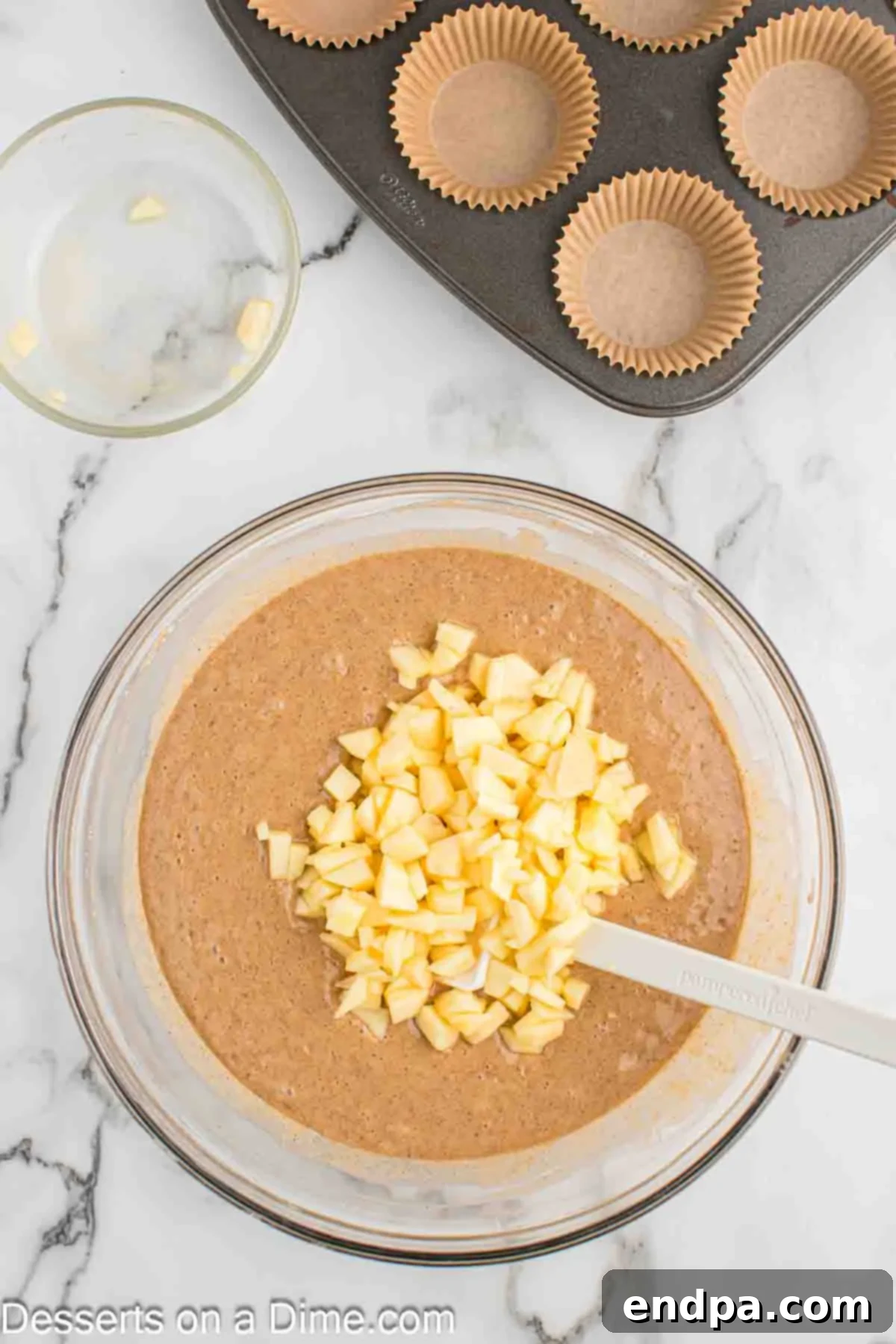 Sticky Caramel Apple Swirl Cupcakes 6 Chopped apples being gently folded into the cupcake batter.