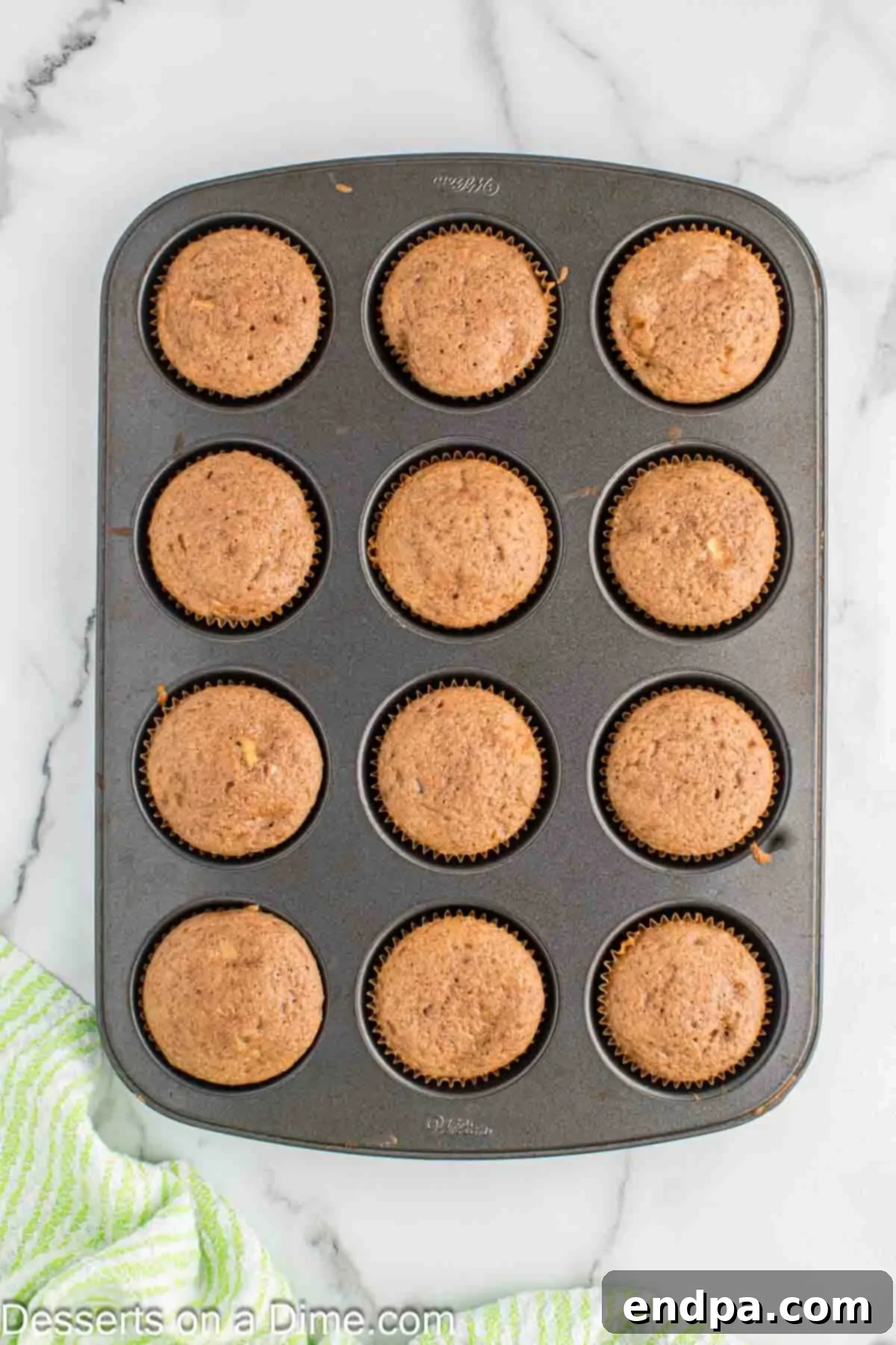 Sticky Caramel Apple Swirl Cupcakes 7 Cupcakes baked golden brown in a muffin pan.