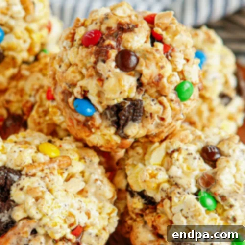 Loaded Popcorn Balls with pretzels and Oreo pieces visible, covered in a marshmallow coating.