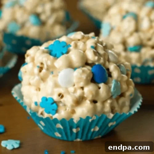 White Popcorn Snowballs adorned with blue sprinkles and M&M's, perfect for winter.