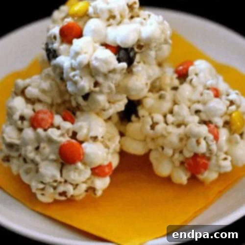Fall Popcorn Balls studded with orange, yellow, and brown Reese's Pieces.
