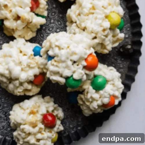 Colorful M&M Popcorn Balls, a fun and crunchy chocolatey treat.