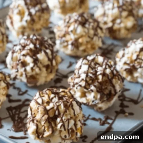Toffee Pecan Popcorn Balls with a tempting chocolate drizzle.