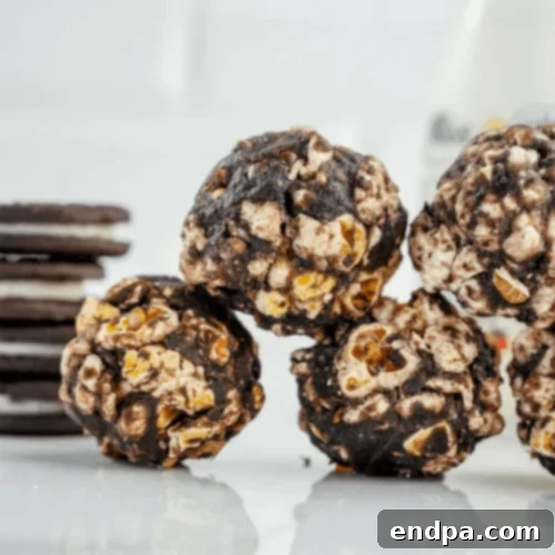 Oreo Popcorn Balls, speckled with crushed Oreo cookie pieces.