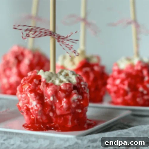 Red Candy Apple Popcorn Balls, glistening with a sweet, caramelized glaze.