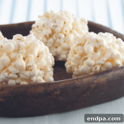 Soft and chewy Mallow Popcorn Balls, coated in a sweet marshmallow mixture.