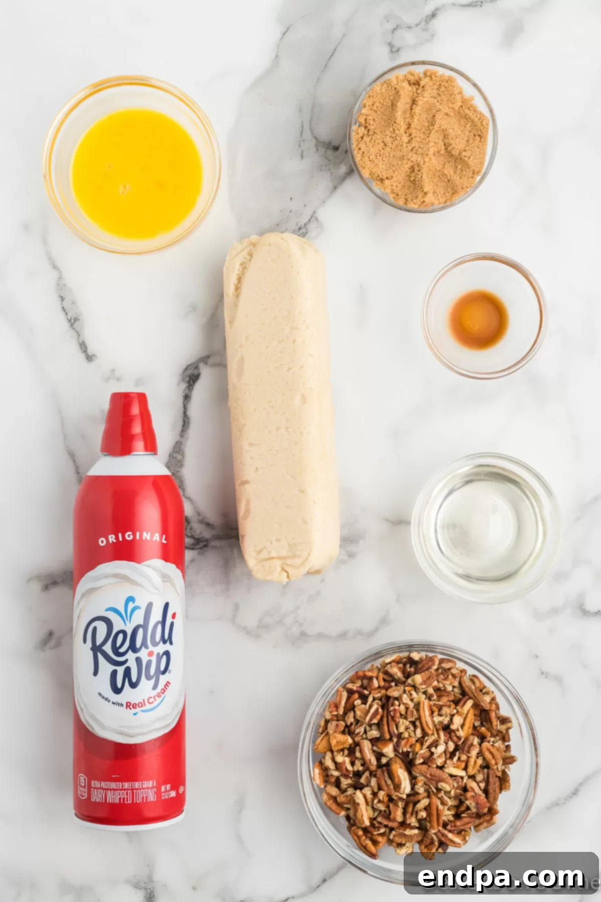 Pecan Pie in a Cookie 3 Arrangement of ingredients for pecan pie cookies, including cookie dough, brown sugar, vanilla, and pecans, with whipped cream for serving.