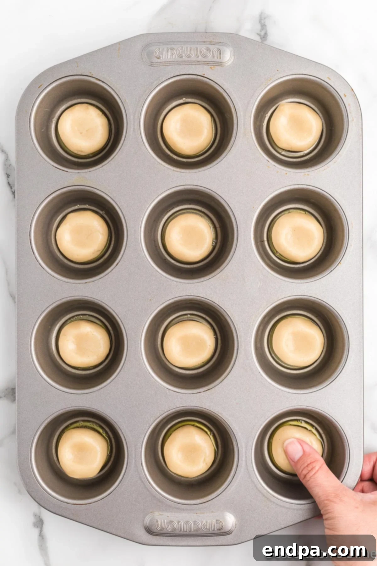 Pecan Pie in a Cookie 4 Sugar cookie dough balls pressed into a mini muffin pan, creating an indentation for the filling.