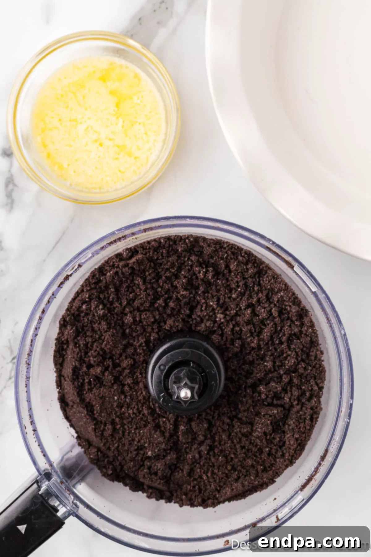 Decadent No Bake Nutella Cheesecake 4 Crushed Oreo cookies in a food processor, ready to be mixed for the cheesecake crust.