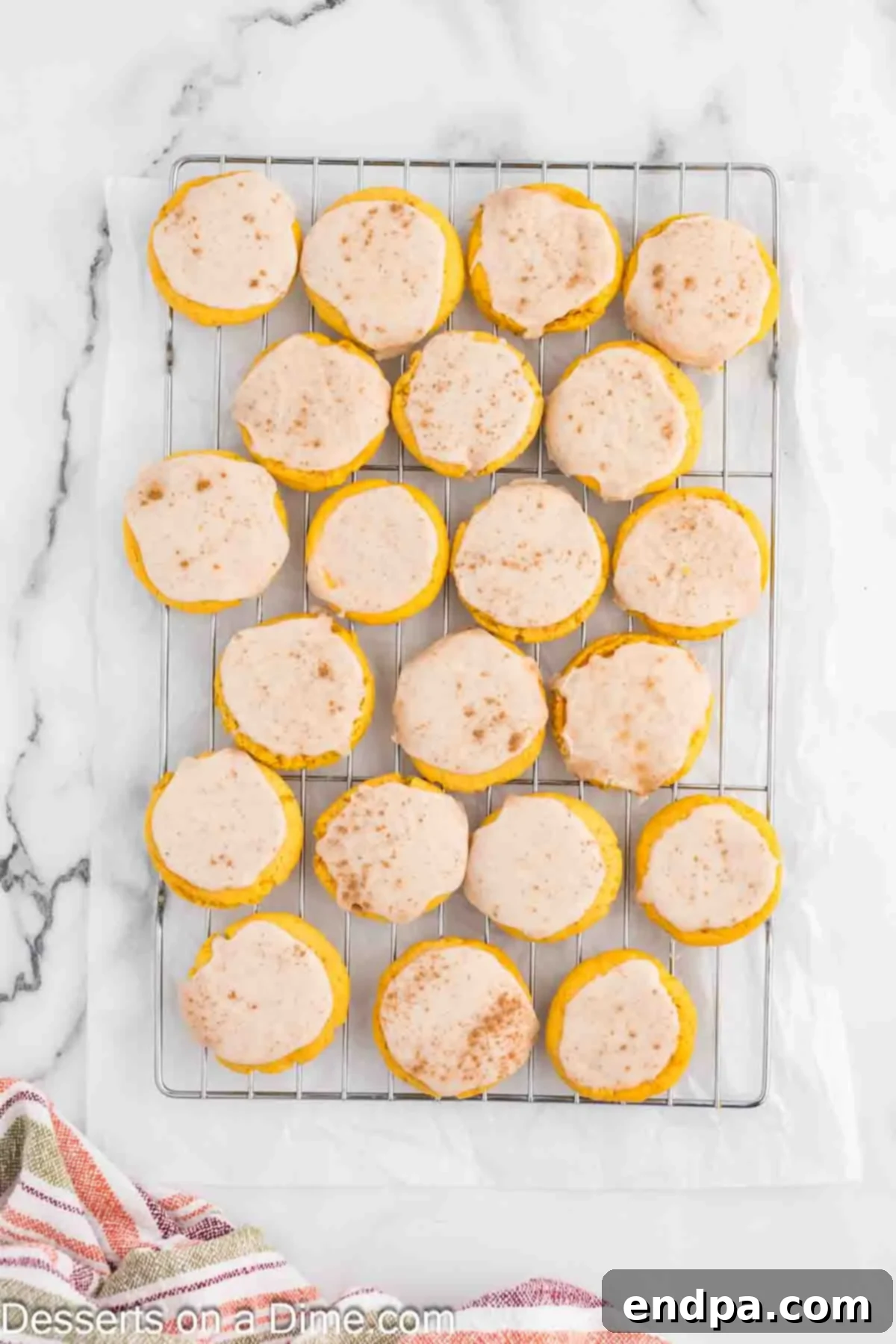 Glazed pumpkin sugar cookies drying on a wire rack, allowing the sweet and spiced glaze to set and harden perfectly before serving.