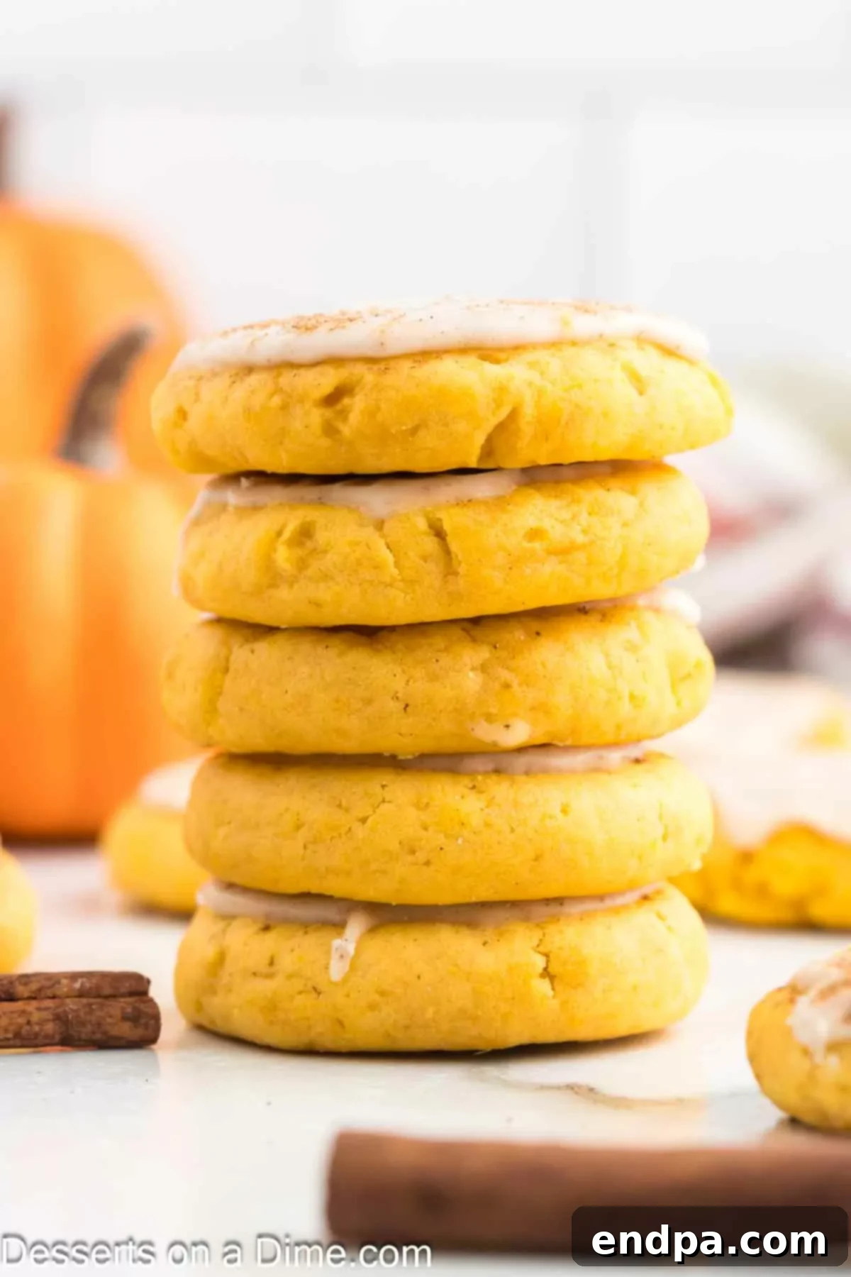 A stack of beautifully glazed and spiced pumpkin sugar cookies, showcasing their soft texture and inviting autumn colors, ready to be enjoyed as a delightful fall treat.