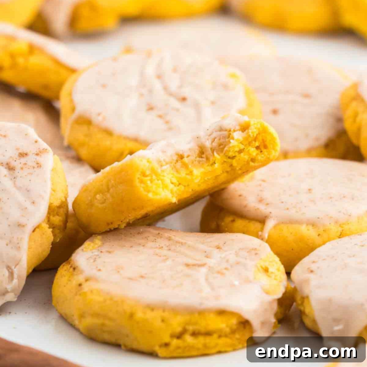 Pumpkin sugar cookies stacked together, showcasing their soft texture and delightful glaze.