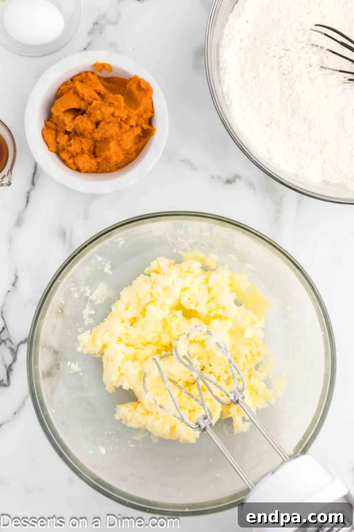 Softened butter being creamed with granulated sugar in a stand mixer, demonstrating the process of beating until the mixture is light and fluffy.